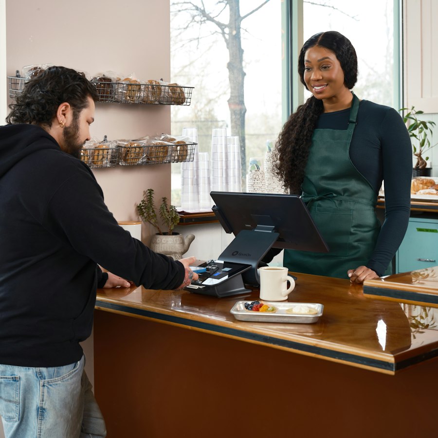 Cliente pagando no balcão de uma franquia
